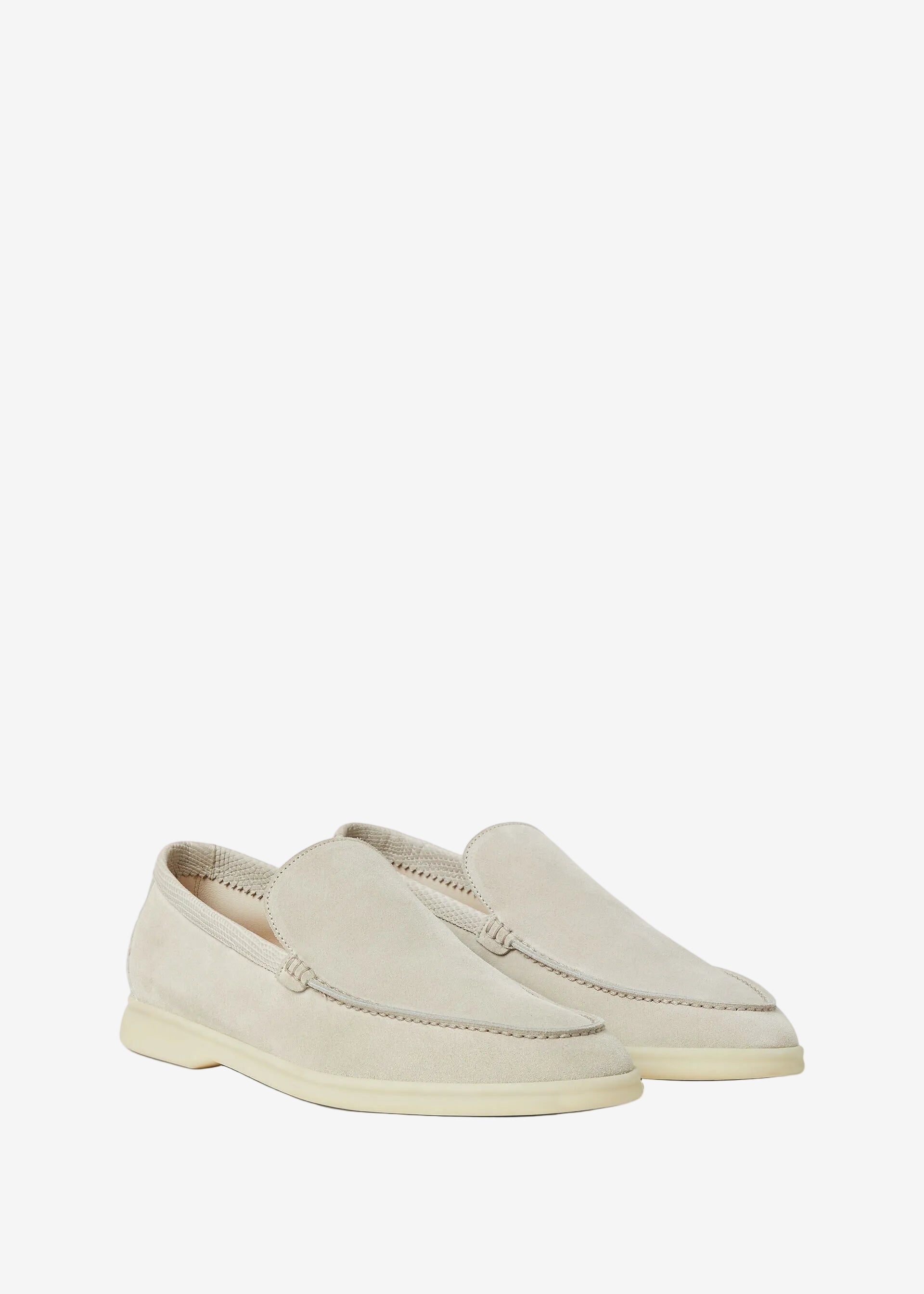 Pair of light-colored loafers on a white background